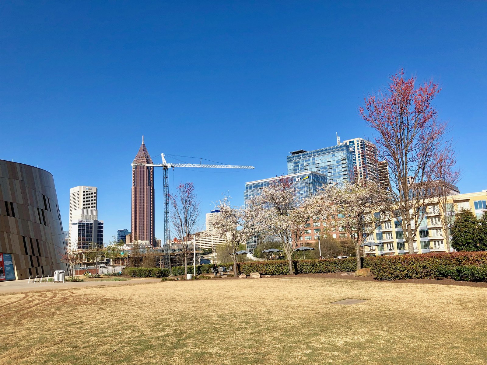 Downtown Atlanta skyline viewed from Pemberton Place beneath a clear blue sky.