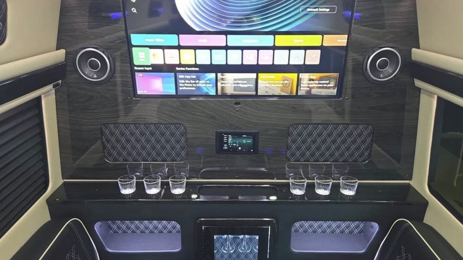 Luxury passenger van rear entertainment wall with a large screen, speakers and touchscreen controls