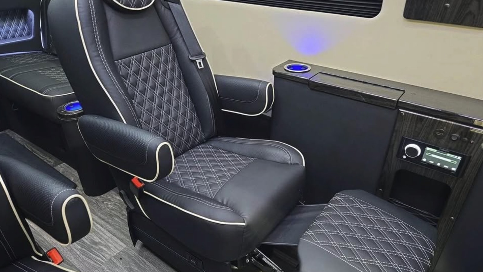 Black diamond-quilted luxury van captain's chair with light piping, cream panels and dark wood trim