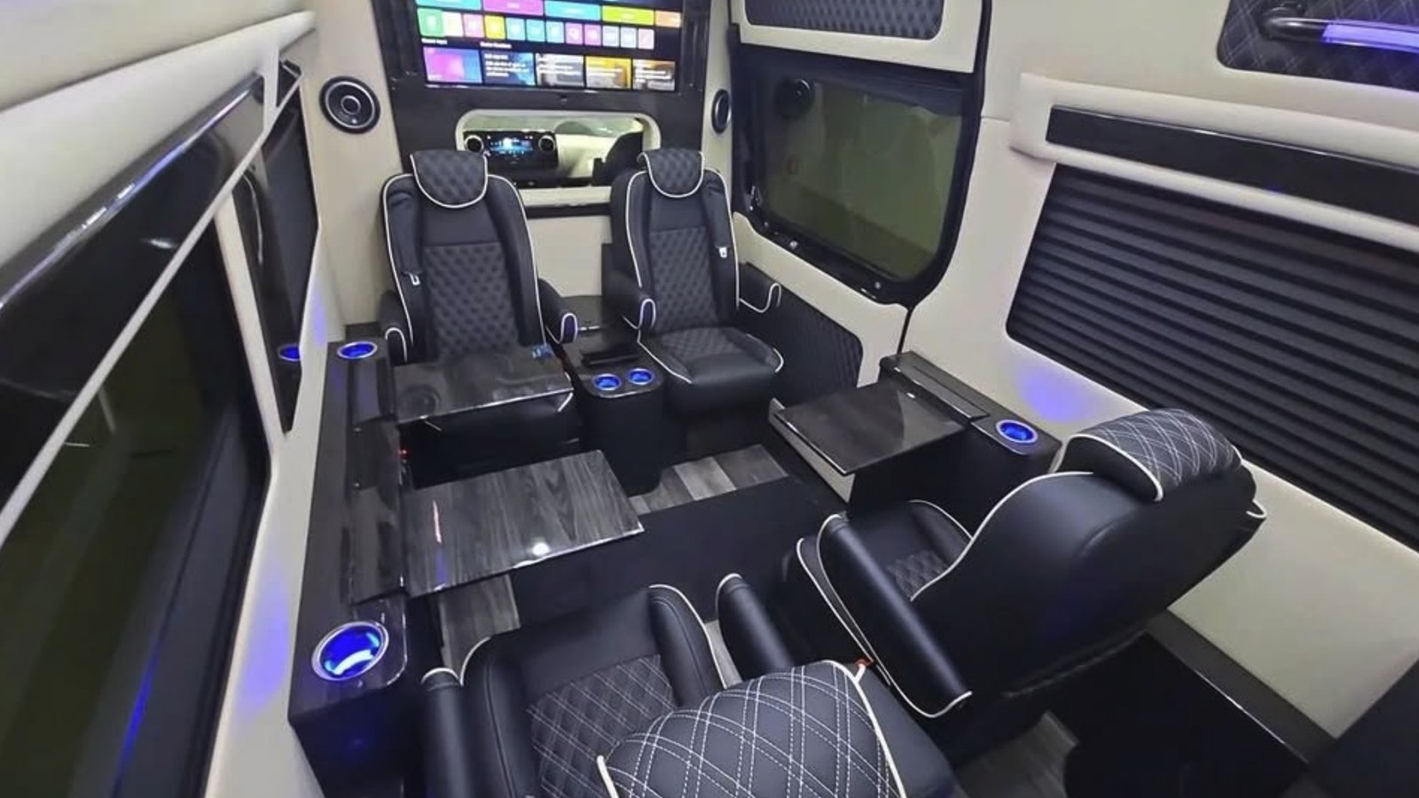 Partitioned rear cabin of the listed Ultimate Toys Ultimate Limo with captain’s chairs, tables and entertainment screen