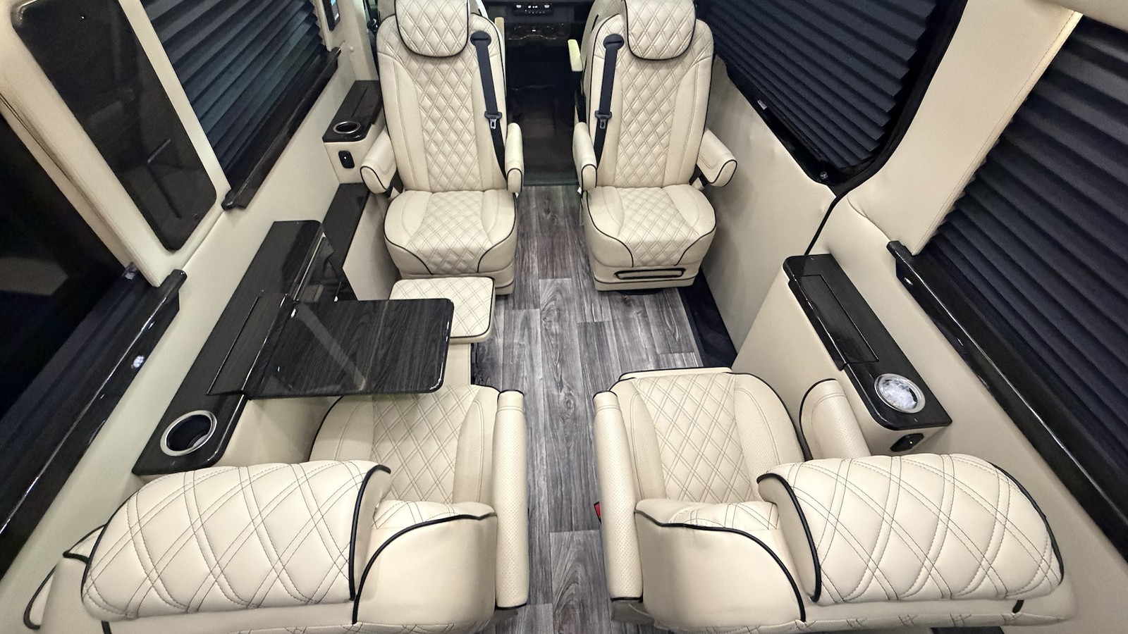 Luxury passenger van cabin with individual cream captain’s chairs and rear seating