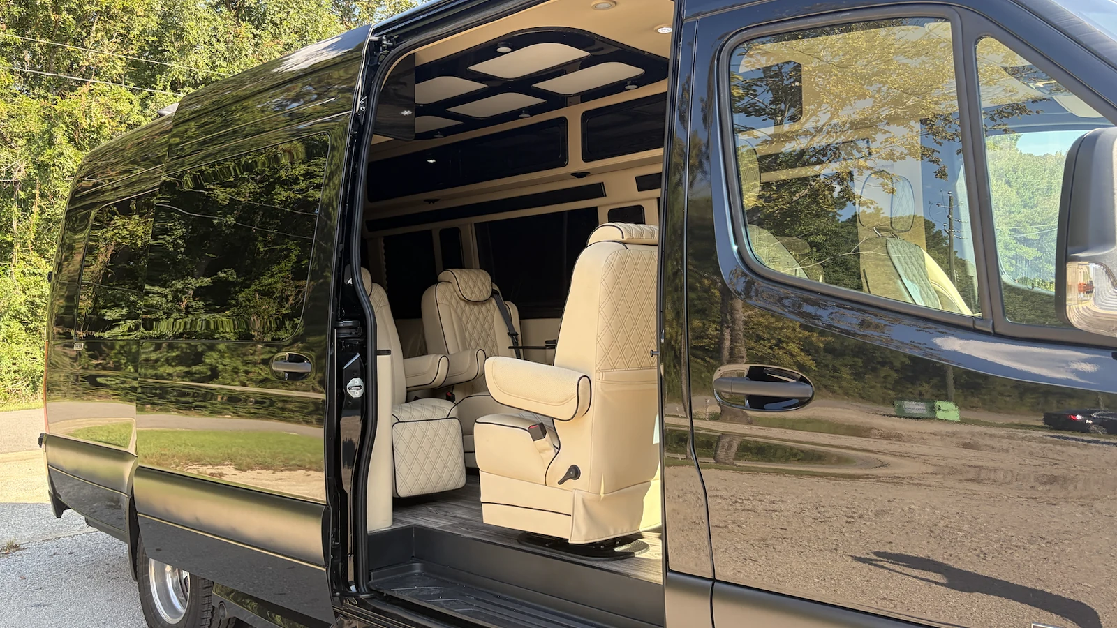 Open luxury Sprinter cabin with cream captain's chairs and soft ceiling lighting
