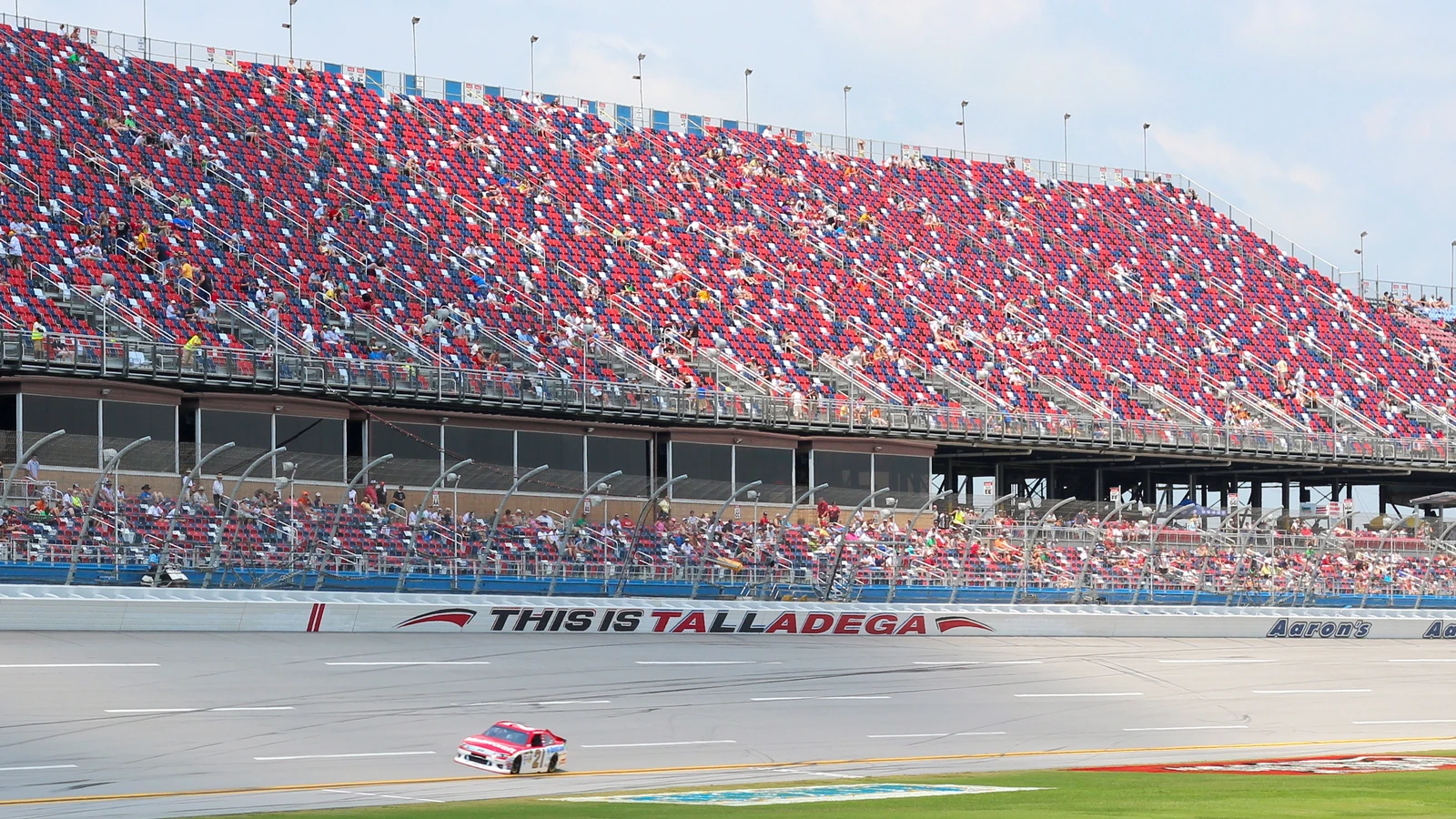 Race car passing the frontstretch grandstands at Talladega Superspeedway