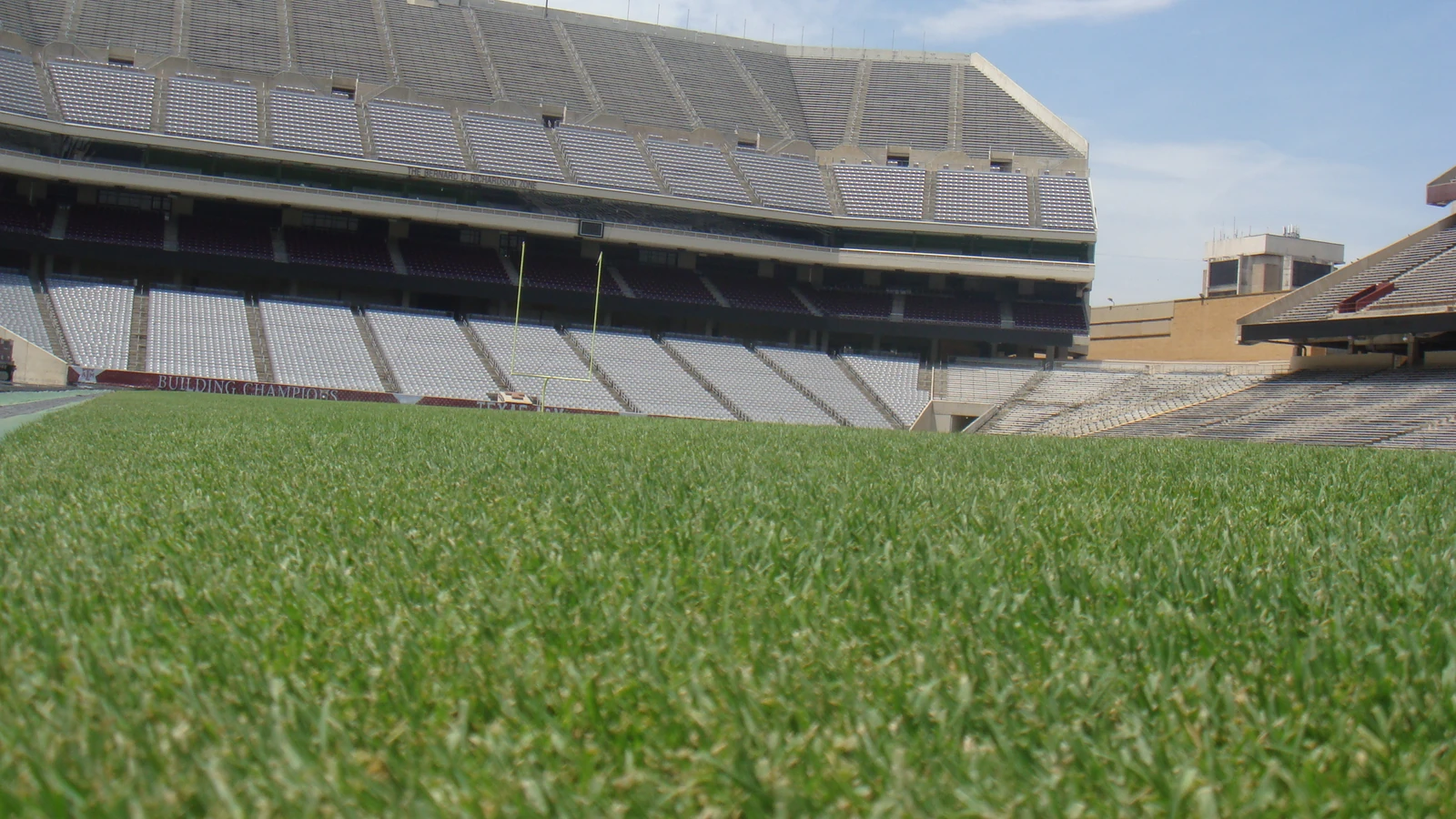 Field-level view across the grass toward the seating decks at Kyle Field in College Station, Texas