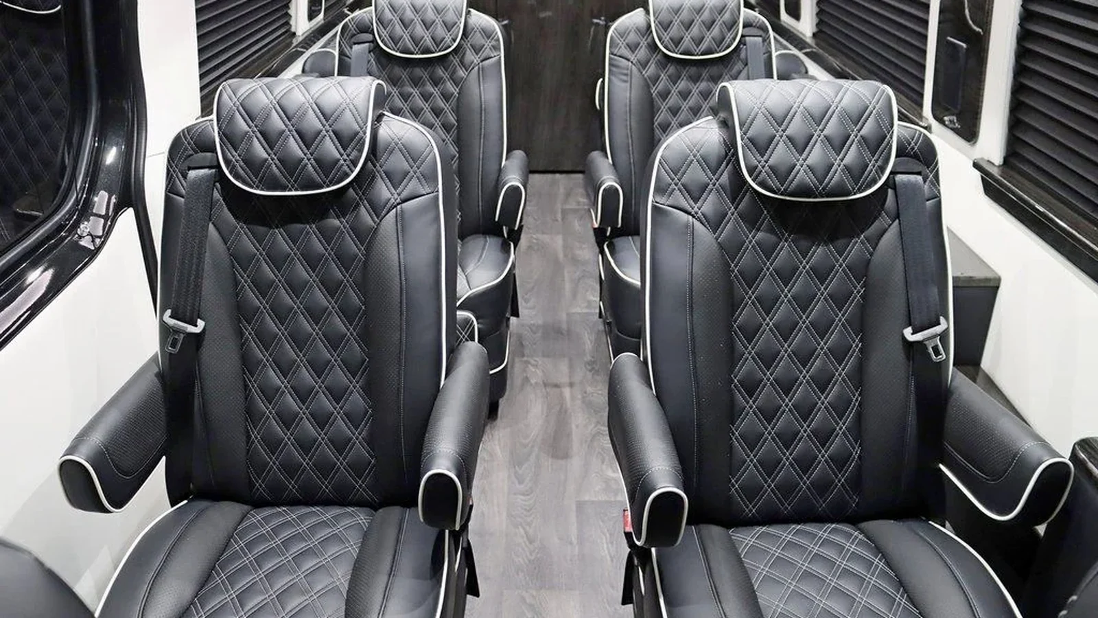 Illustrative grey quilted passenger seats in a luxury van; not identified as an Ultimate Freedom and not a model comparison photograph.